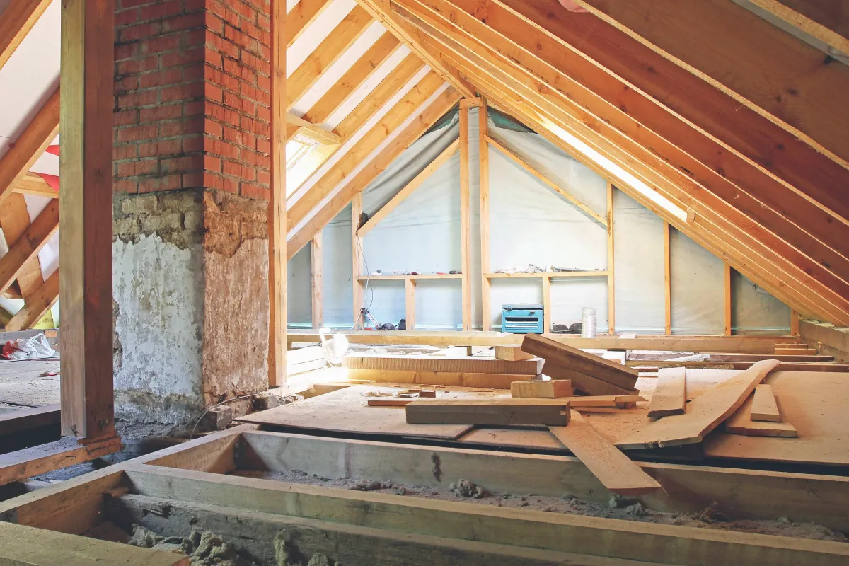 Loft installer fitting a clean white loft board over insulation